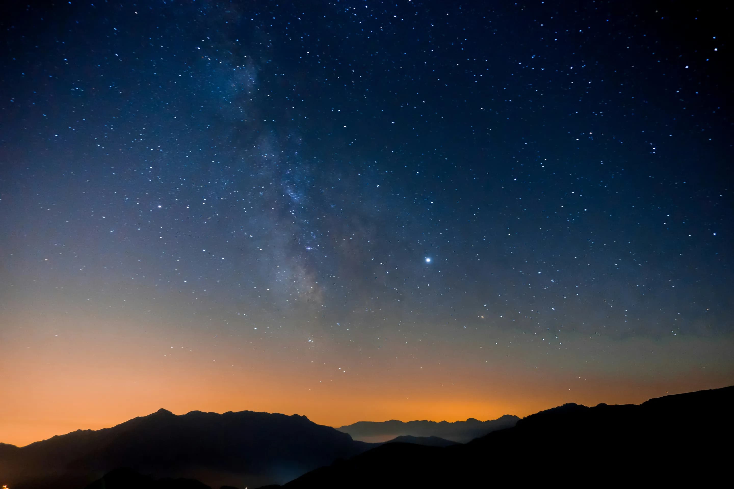 Milky Way arcing over mountain silhouettes