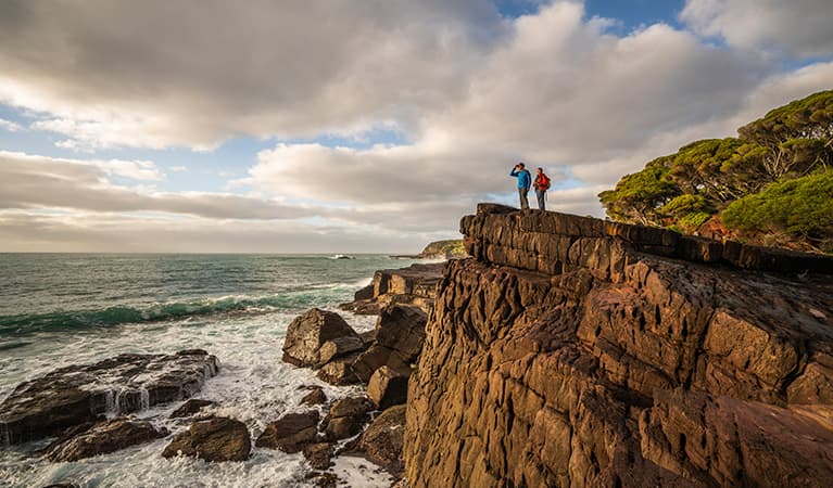 Bushwalkers on cliffside, Bittangabee campground, Beowa National Park. Photo: John Spencer/OEH