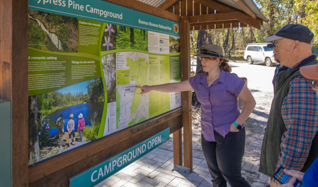 Visitors reading the Cypress Pine campground sign. Credit: Joshua J Smith © DPIE