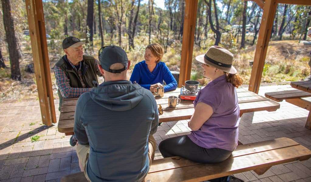 Campers siting at picnic tables, Cypress Pine campground. Credit: Joshua J Smith © DPIE