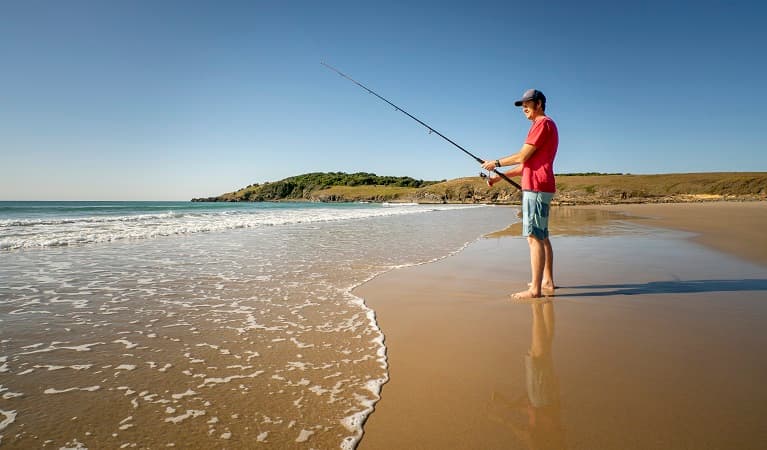 A man on Goolawah beach fishing nearby Racecourse campground, Goolawah National Park. Photo: John Spencer/OEH