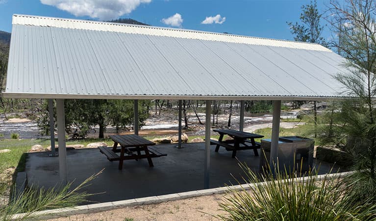 A shelter with picnic tables and a barbecue at Mann River campground and picnic area in Mann River Nature Reserve. Photo: Leah Pippos © DPE