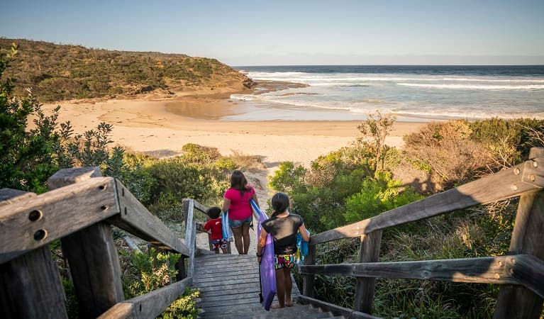 A family walking downstairs to Frazer beach, Munmorah State Conservation Area. Photo: John Spencer/OEH
