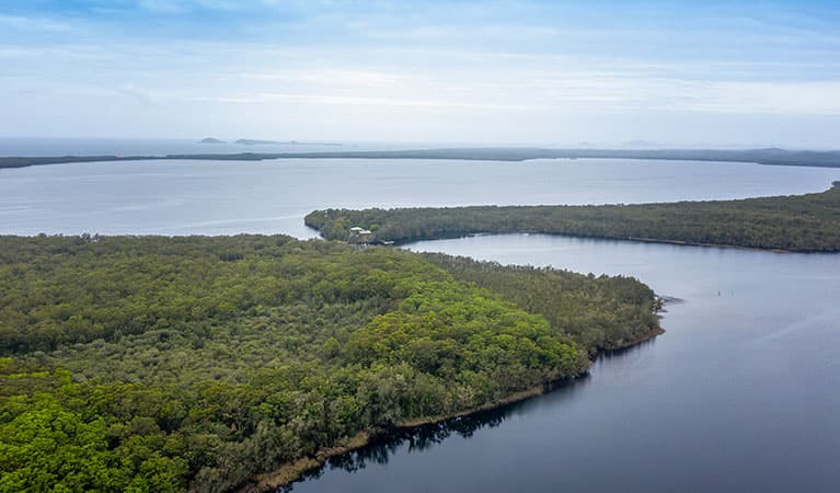 Aerial view of bush and water surrounding Joes Cove campground in Myall Lakes National Park. Photo: John Spencer © DPIE