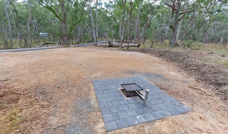 Campsite with an open fire pit with a swivelling BBQ plate over the top, Wollomombi campground, Oxley Wild Rivers National Park. Photo: Robert Cleary © DPE