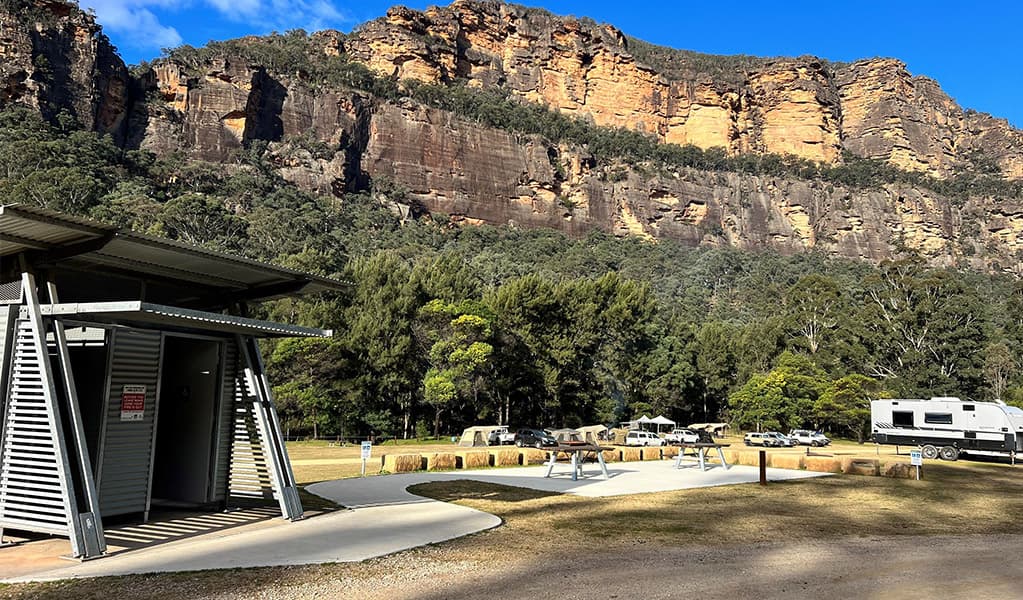 A concrete footpath leads directly from the 2 accessible campsites to the accessible toilet. Credit: © DCCEEW